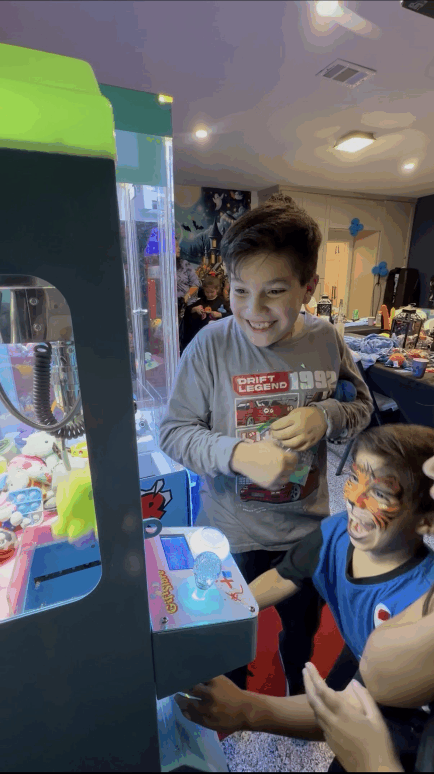 Kids enjoying claw machines at a birthday party in Dallas Texas.